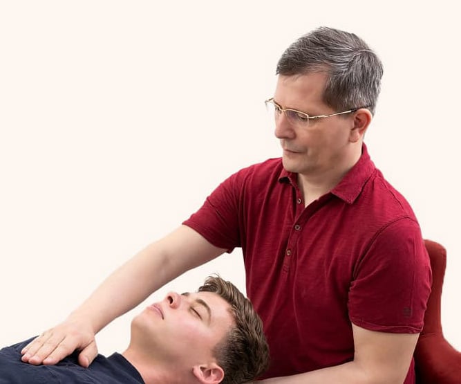 Praktische Anwendung der Cranio-Sacral-Therapie an der Behandlungsliege durch den Ausbildungsleiter
